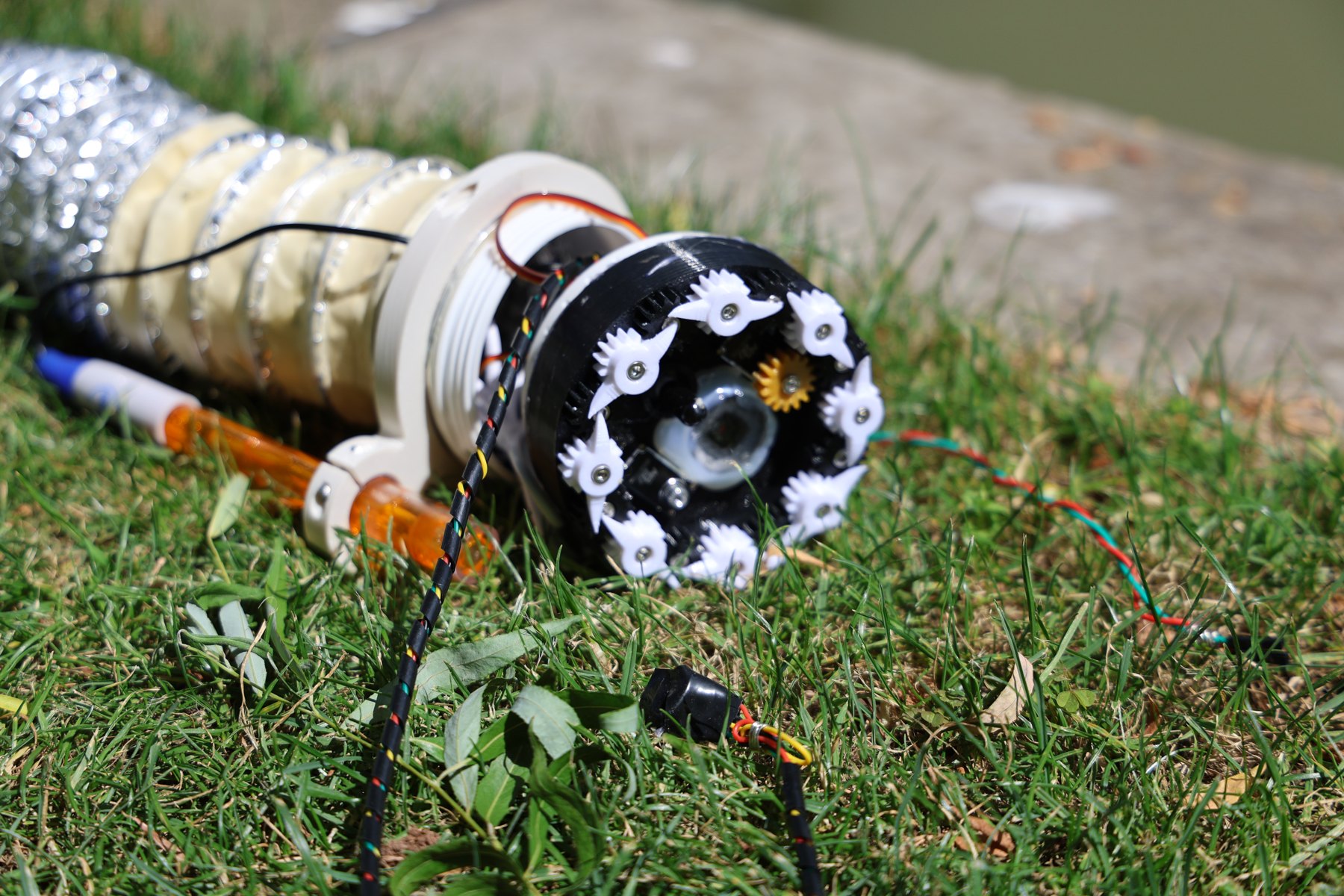 The environmental sensing robot resting on grass beside a waterway.