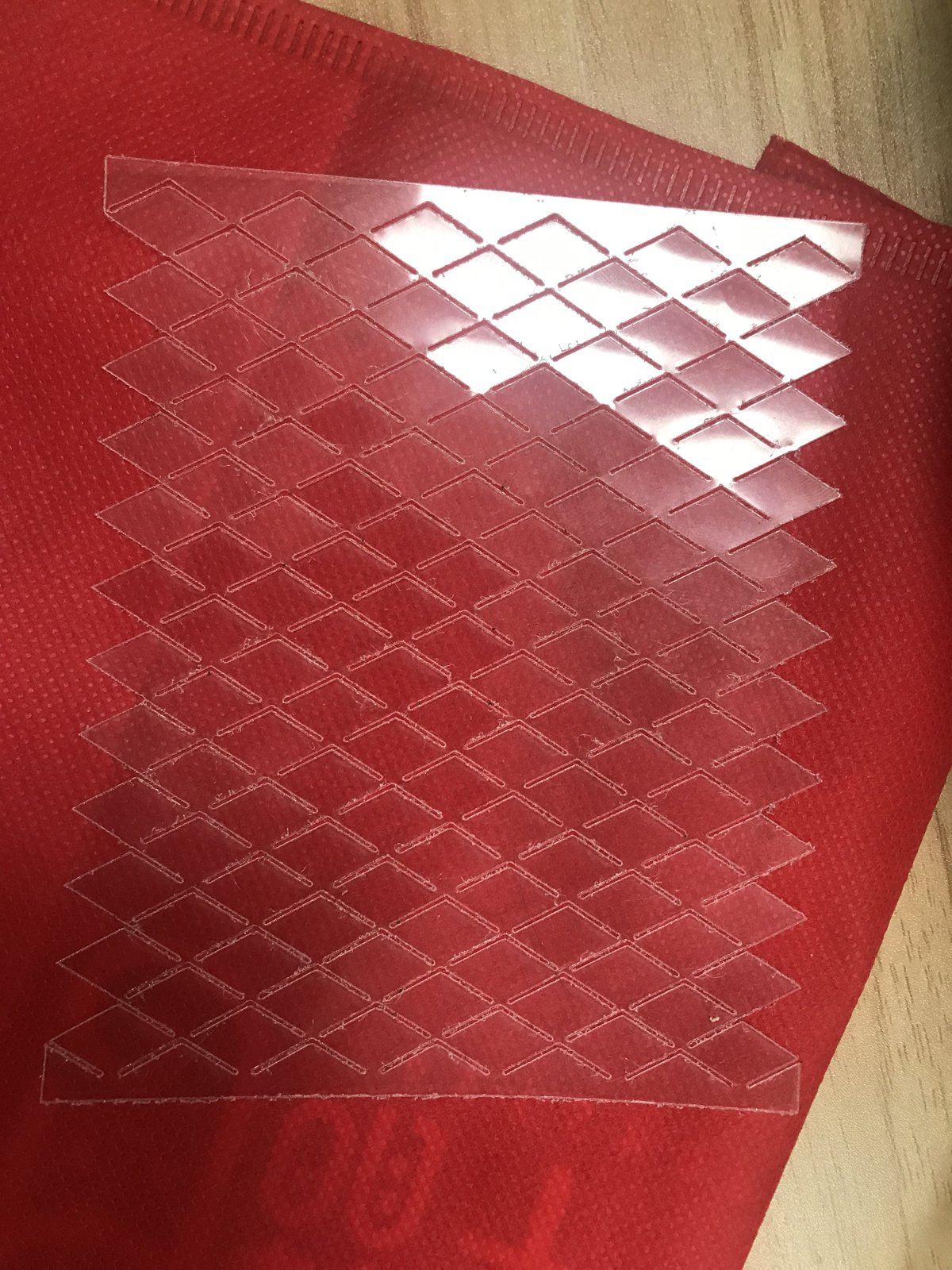 A laser-cut PET sheet with a repeating kirigami pattern.